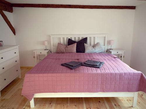 ein Schlafzimmer mit einem rosa Bett mit zwei Nachttischen in der Unterkunft Stieg 1 in Quedlinburg