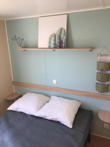 - un lit dans une chambre avec une étagère sur le mur dans l'établissement Tropical Bungalow 1, à Vic-la-Gardiole