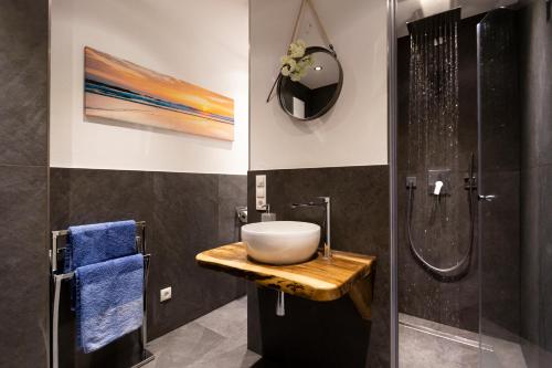 y baño con lavabo y ducha. en AD FONTES Suite mit Bergblick & Sauna en Übersee