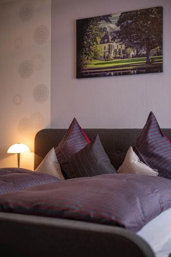 a bedroom with a bed with pillows and a picture on the wall at Landhaus Heimisch Bed & Breakfast in Geisfeld
