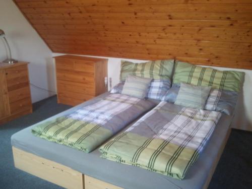 a large bed in a bedroom with a wooden ceiling at Chata Zahrada Madeta in Veselí nad Lužnicí