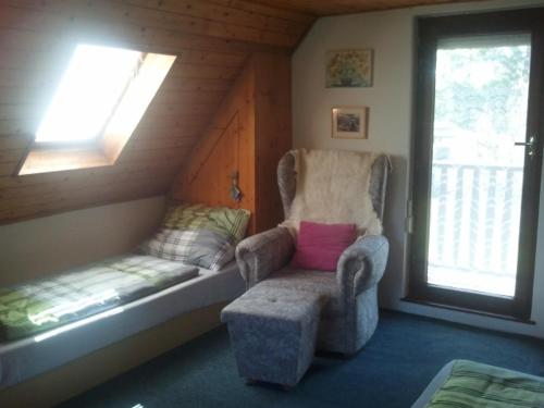 a room with a chair and a bench and a window at Chata Zahrada Madeta in Veselí nad Lužnicí