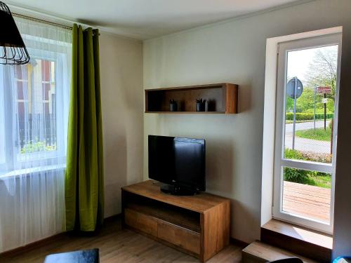 Una sala de estar con televisión y una ventana. en Apartmán Wake u aquaparku, en Česká Lípa