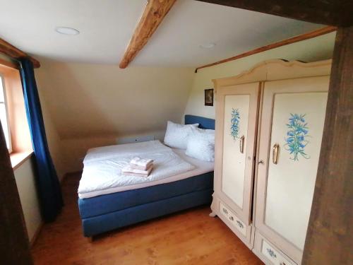 a small bedroom with a bed and a cabinet at Pferdehof am Burgsberg, Ferienwohnungen in Seifhennersdorf