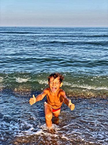 a young boy running in the water on the beach at Villa Camilla, Затока in Zatoka