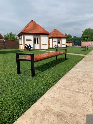 a park bench with a house in the background at Bungalovi Blagojević in Morović
