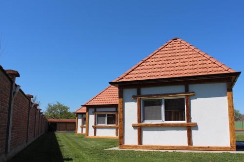 a small house with a red roof on a yard at Bungalovi Blagojević in Morović