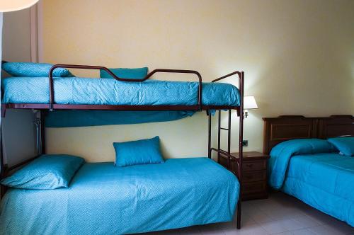 two bunk beds in a room with blue sheets at Alloggio turistico Luigina in Morro Reatino