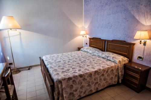 a small bedroom with a bed and two lamps at Alloggio turistico Luigina in Morro Reatino