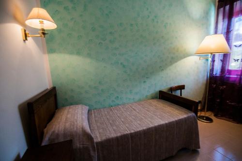 a bedroom with a bed and two lamps on the wall at Alloggio turistico Luigina in Morro Reatino