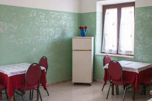 a room with a table and chairs and a refrigerator at Alloggio turistico Luigina in Morro Reatino