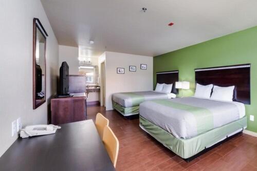 a hotel room with two beds and a television at Eagle Ford Inn in Floresville