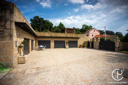 a brick parking lot in front of a house at Casas do Picoutinho in Ponte de Lima