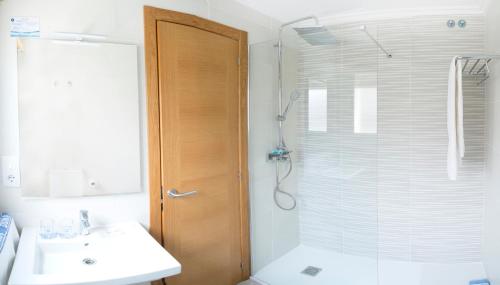 a bathroom with a shower and a sink and a glass door at Hotel Duna in Portonovo