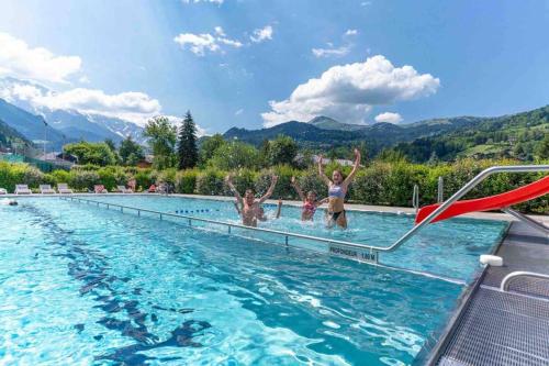un groupe de personnes dans une piscine dans l'établissement Appartement spacieux proche des télécabines et du centre ville avec jardin privé, à Saint-Gervais-les-Bains