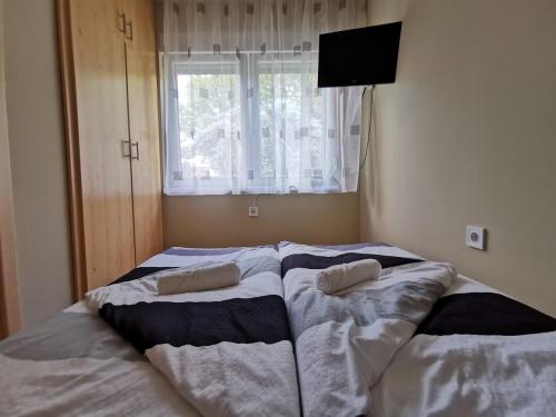 a bedroom with a bed with two pillows on it at Pelso Apartman in Siófok