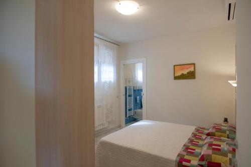 a white bedroom with a bed and a window at Borgo dell'Uccellaia - Turchese - Giada in Marciana Marina