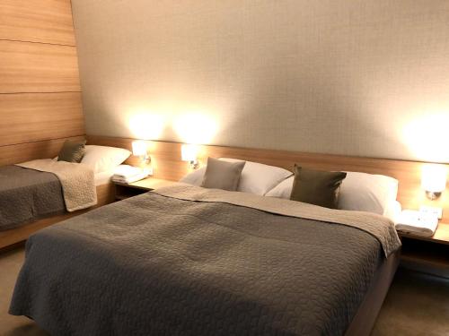 um quarto de hotel com duas camas e duas lâmpadas em Hrebienok C217 em Starý Smokovec