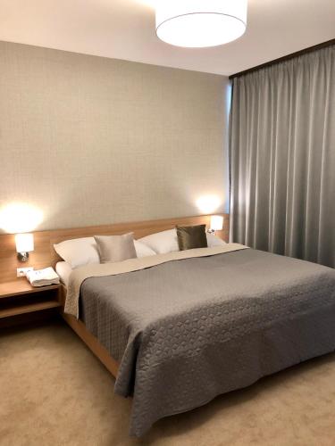a bedroom with a large bed and two lamps at Hrebienok C217 in Starý Smokovec