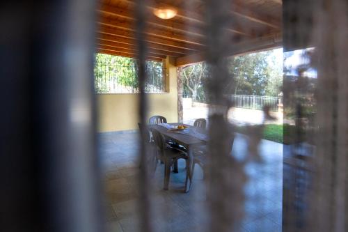 a table and chairs in a room with a porch at Borgo dell'Uccellaia - Turchese - Giada in Marciana Marina