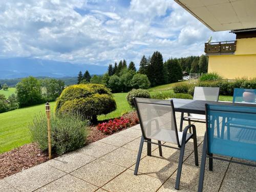 a table and chair on a patio with a garden at Ferienhaus Karawankenblick in Wurzen