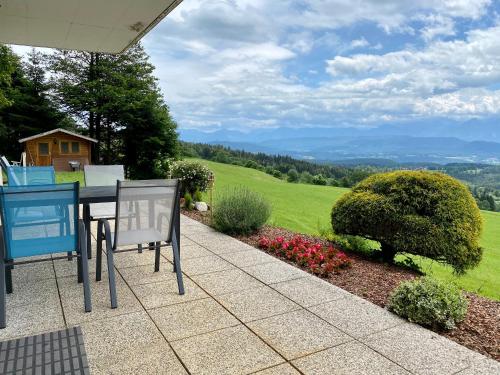 a table and chairs on a patio with a view at Ferienhaus Karawankenblick in Wurzen
