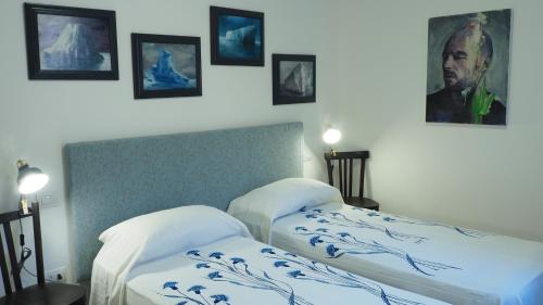 2 camas en una habitación con fotos en la pared en R&B Giardino 34 en Forlì