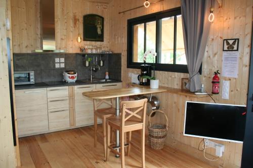 une cuisine avec une table et des chaises dans une pièce dans l'établissement Gîte de l'océan, 3 étoiles - Les cabanes océanes, Montalivet, à Vendays-Montalivet