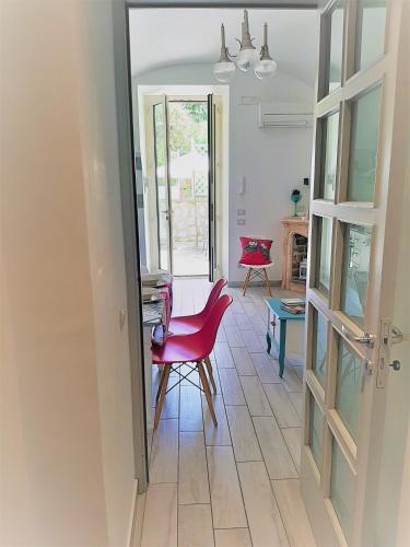 a room with a red chair and a table at Dreaming Sorrento Suites in Sorrento