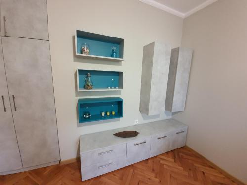 a kitchen with a counter and shelves on the wall at Danny apartment in Burgas City
