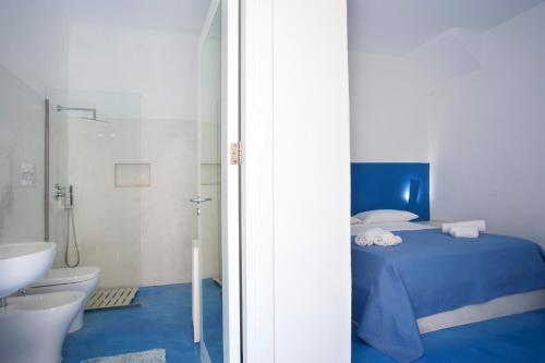 a bathroom with a bed and a toilet and a sink at Blusanvito in San Vito lo Capo