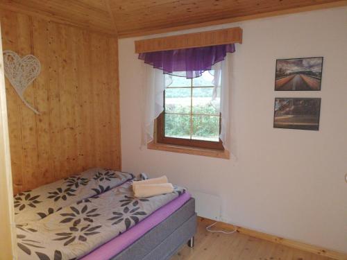 a small bedroom with a bed and a window at Apartment AliS in Tønjum