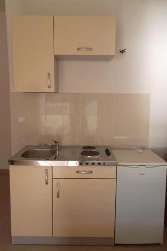 a white kitchen with a sink and a stove at Apartments with sea view Drvenik Makarska riviera in Drvenik