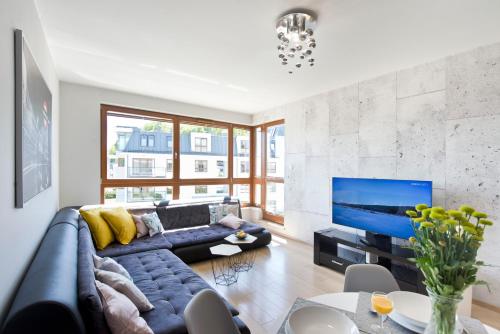 salon z niebieską kanapą i telewizorem w obiekcie Pomorskie Apartamenty Aquarius w mieście Sopot