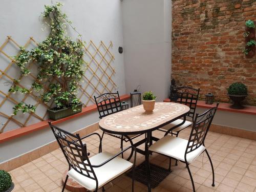 einen Tisch und Stühle in einem Zimmer mit Pflanzen in der Unterkunft Nell'antico ghetto ebraico in Ferrara