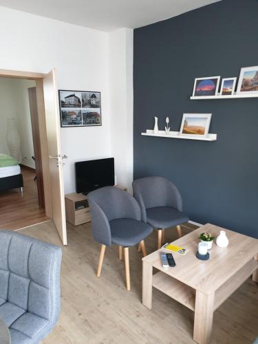 een woonkamer met 2 stoelen en een tafel bij Ferienwohnung am Kiessee in Breitungen