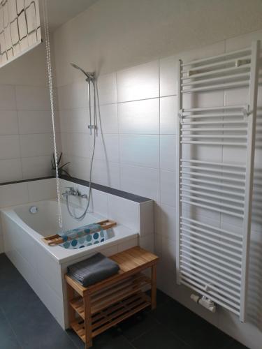 een witte badkamer met een bad en een douche bij Ferienwohnung am Kiessee in Breitungen