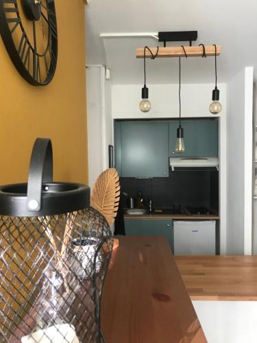 a dining room with a table and a clock on the wall at appartement cosi proche de tout in Biarritz