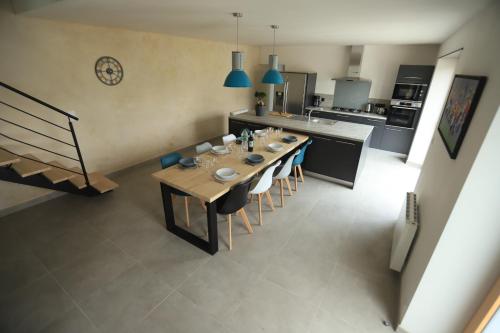 uma cozinha com uma mesa longa e cadeiras num quarto em Gîte de Ty Nevez, Bretagne (Santec) spa, 300 m de la plage. em Santec