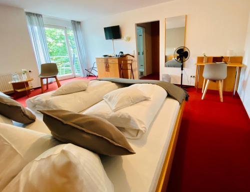 ein Hotelzimmer mit 3 Betten in einem Zimmer in der Unterkunft Zur Kapelle in Kressbronn am Bodensee