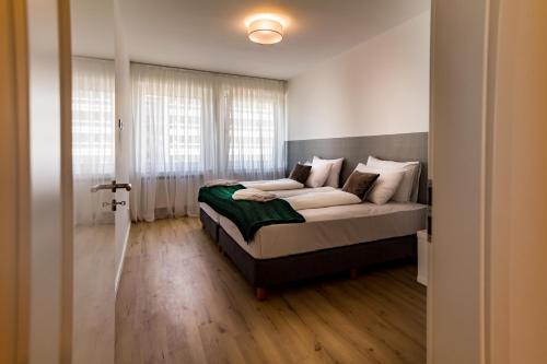 a bedroom with a bed and a large window at Sleep Inn Wehrhahn Suites in Düsseldorf