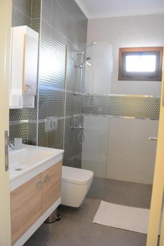 a bathroom with a shower and a toilet and a sink at Maye Residence in Gümbet