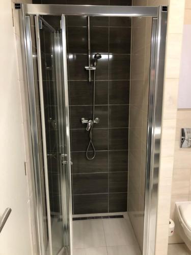 a shower with a glass door in a bathroom at Hrebienok D407 in Starý Smokovec