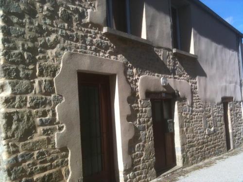 een stenen gebouw met een deur en een raam bij Chez charline in Sainte-Mère-Église