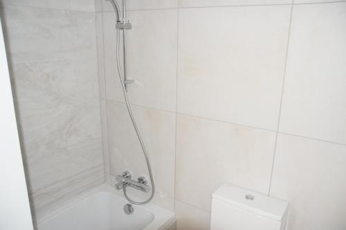 a white bathroom with a shower and a toilet at Tala Luxury apartments with pool by Raise in Tala