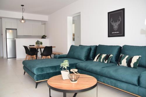 a living room with a blue couch and a table at Tala Luxury apartments with pool by Raise in Tala