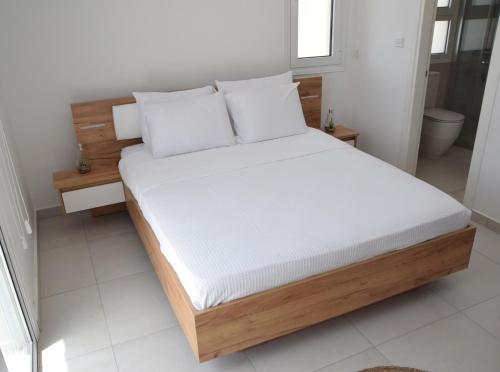 a bed with white sheets and pillows in a room at Tala Luxury apartments with pool by Raise in Tala