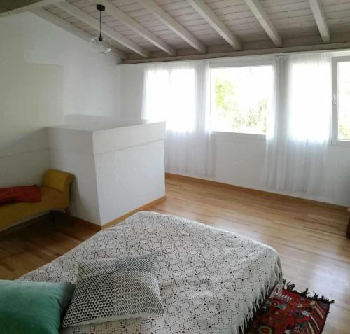 1 dormitorio con cama, sofá y ventanas en like home en Rüti