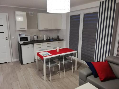 a small kitchen with a red table in a living room at MARKAS in Rewa