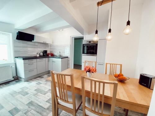 a kitchen with a wooden dining room table and chairs at Drei Linden Herzog in Wolfenbüttel